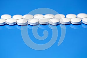 Pills. White medical pills on blue background