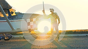 Pilot cleans airplane`s propeller, side view.