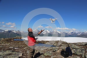 Pilot controls the drone, Romsdalseggen hike, Norway