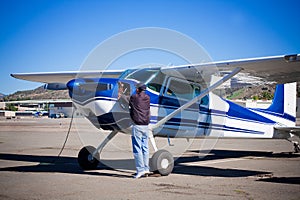 Pilot doing preflight of light aircraft photo