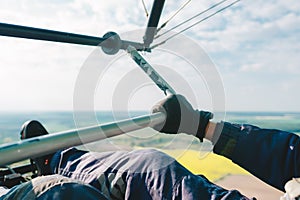 Pilot flying the modern airplane in sunny sky over a big field. Hands of pilot closeup