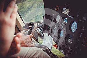 Pilot hand driving a helicopter above Kauai, US