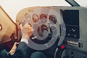 Pilot hand or private flight captain control airplane with many aircraft gauge in cockpit dashboard