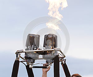 Pilot hand regulating gas burner preparing balloon for flight, fire burning