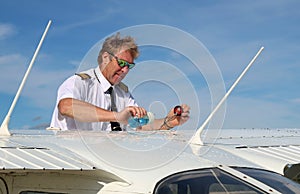 Pilot pouring fuel into tank after pre-flight check - safety first concept