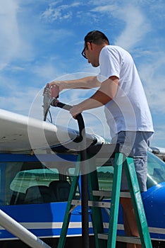 Pilot refueling small airplane