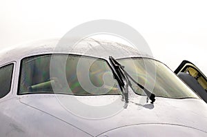 The pilot`s cockpit aircraft with wipers on the windshield, rain drops of water in cloudy weather.