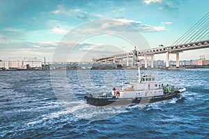 pilot ship or Tug ship in is guiding a large Cruise ship boat out to the ocean in Yokohama Japan