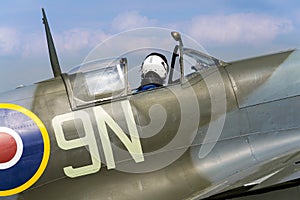 Pilot sits in cockpit of Supermarine Spitfire british fighter aircraft