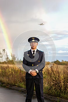 Pilot stands on runway rainbow  nature landing plane behind