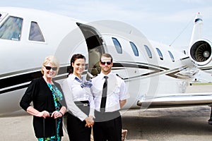 Pilot and stewardess with passenger by plane