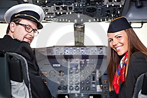 Pilot and stewardess sitting in an airplane cabin