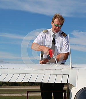 Pilot in uniform fuelling up cessna aiplane