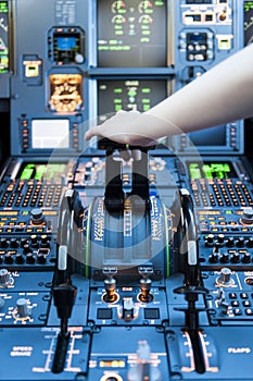 Piloting in an Airplane Cockpit with thrust levers with hand on top for takeoff photo