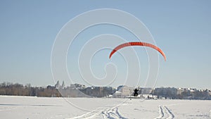 The pilots of the paraglider are rising into the air. Competitions of paragliders on the frozen lake. Ternopil Ukraine