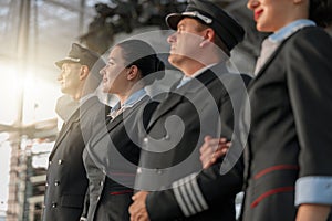 Pilots and stewardesses standing in a row at the airport