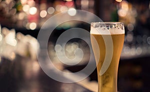 Pilsner beer glass with bar background