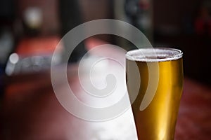 Pilsner beer glass on a table