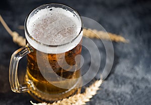 Pilsner beer mug on dark pub table with copyspace