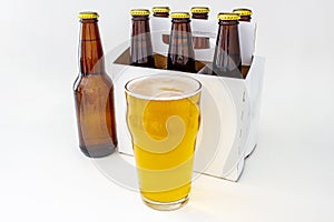 A Pilsner Style Lager brown bottle sic pack with a full pint of beer