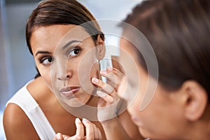 Pimple, woman and skincare in mirror with pores or face spot or acne on cheek. Home, female person and serious with