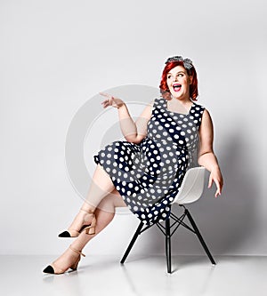 Pin up a female portrait. Beautiful retro fat woman in polka dot dress with red lips and old-style haircut