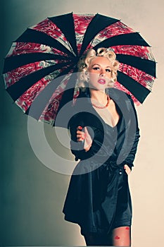 Pin-up girl. American style. Women in Black Coat with Umbrella