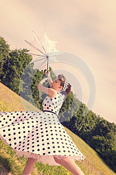 Pin up Girl with broken umbrella, wind is blowing off
