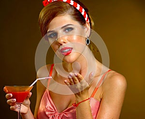 Pin up girl drink red martini cocktails and blow kiss