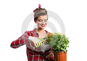 Pin-up girl holding flower pot with yellow daisies and shears