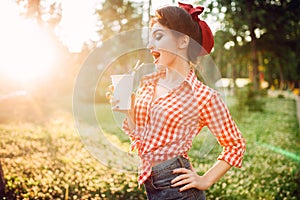 Pin up girl holds cardboard cup with a straw