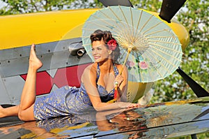 Pin up girl posing with a vintage fighter plane