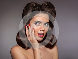 Pin up girl surprised with red lips makeup and manicured nails,