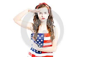 Pin up girl wrapped in american flag saluting