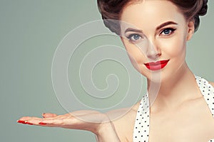 Pin up woman portrait. Beautiful retro female in polka dot dress with red lips and manicure nails and old fshion hairstyle hand