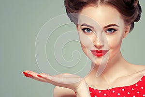 Pin up woman portrait. Beautiful retro female in polka dot dress with red lips and manicure nails and old fshion hairstyle hand