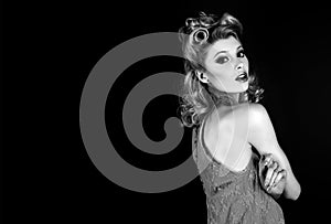 Pin up woman portrait. Beautiful retro female with red lips and old fashion hairstyle. Studio shot on black background.