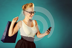 Pin up woman with shopping bag and phone.