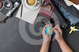 Pin on the world map and Prepare a suitcase  on black background. travel concept