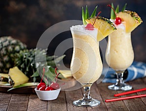 Pina colada cocktail with cherry, pineapple and leaves