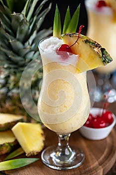 Pina colada cocktail with cherry, pineapple and leaves