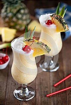 Pina colada cocktail with cherry, pineapple and leaves