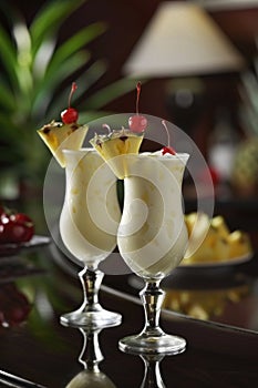 Pina colada cocktails garnished with pineapple wedges and cherries. Studio photography with tropical bar concept. Design for menu