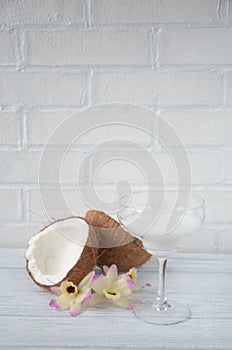 Pina colada drink in cocktail glass decorated with coconut and orchid flowers