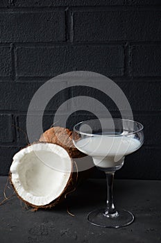 Pina colada drink in cocktail glass decorated with coconut and orchid flowers