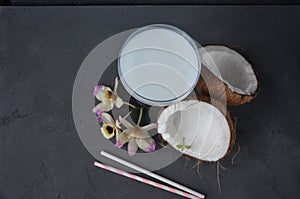 Pina colada drink in cocktail glass decorated with coconut and orchid flowers