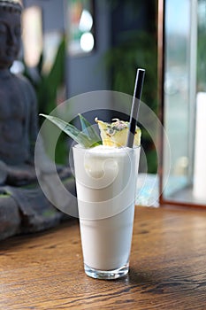 Pina colada drink decorated with pineapple leaves. Cocktail based on rum, coconut milk and pineapple in a long glass.