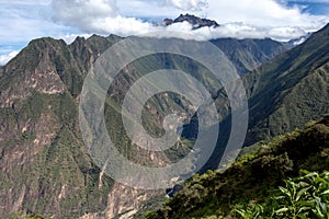 Pinchinuyok ancient Inca ruins surrounded by mountain peaks and clouds above the green canyon in Peru photo