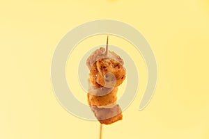 Pincho of home-made croquettes of ham, typical Spanish dish on yellow background