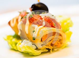 Pincho roll with olives on salad leaf